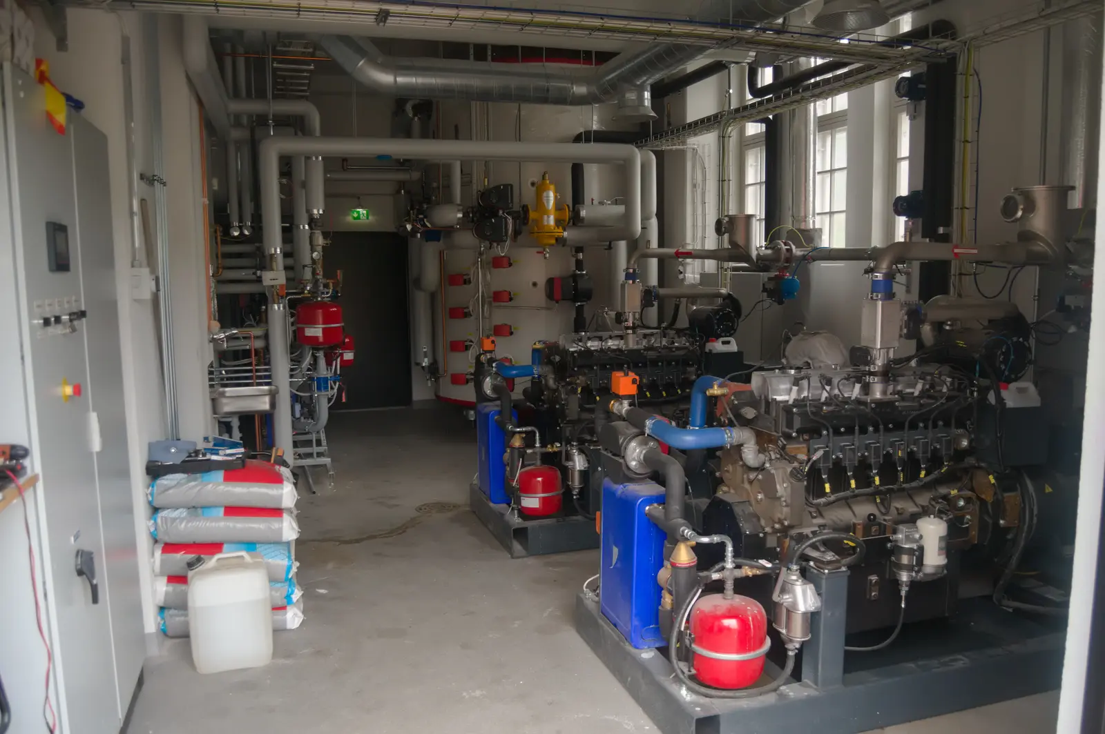 Interior of an energy plant with CHP modules, pumps and buffer storage